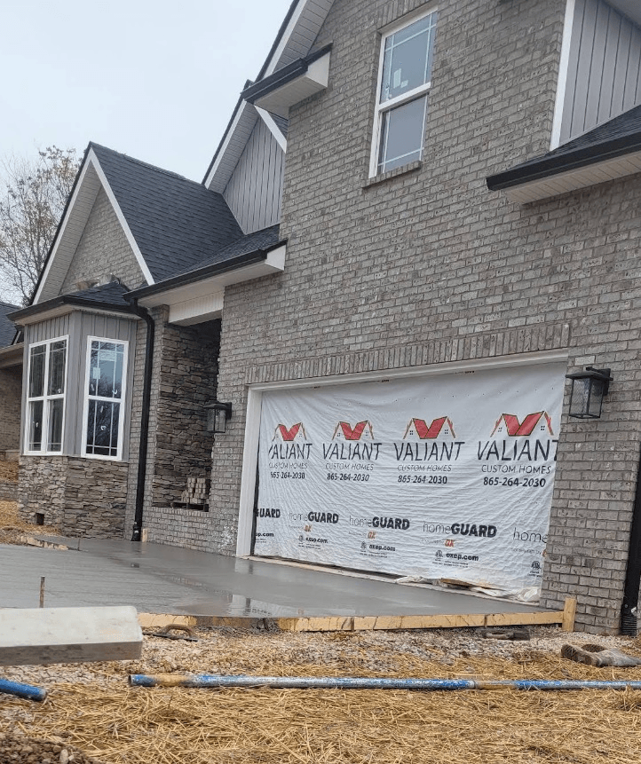 Brick and stone home with freshly poured concrete driveway after exterior cleaning work